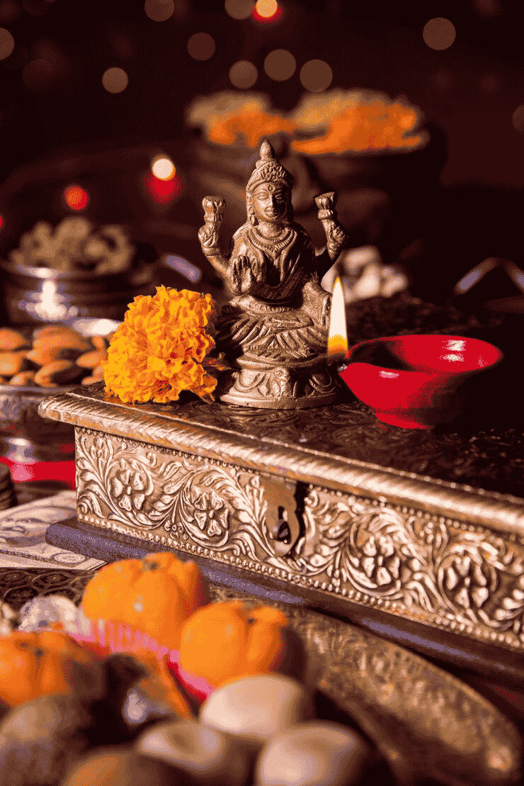 Deity statue with flowers and candles for puja ceremony